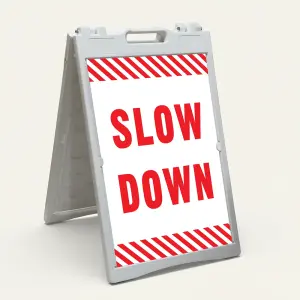 Slow Down sign with red text on white background and diagonal red and white hazard stripes