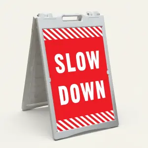Slow Down sign with white text on red background and diagonal red and white hazard stripes