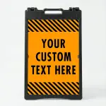 Custom text hazard stripe A-frame sign with orange panel and black diagonal stripes in white frame for Los Angeles business or construction site