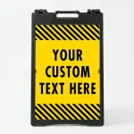 Custom text hazard stripe A-frame sign with yellow panel and black diagonal stripes in white frame for Los Angeles business or construction site