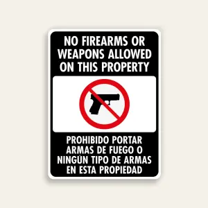 Full black 18x24 vertical Maxmetal sign with bold white English text No Firearms Or Weapons Allowed On This Property at top, white-bordered inset with red circle-slash over handgun icon in center, and Spanish text Prohibido Portar Armas De Fuego O Ningún Tipo De Armas En Esta Propiedad in white at bottom.
