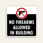 White and black 24x24 square Maxmetal sign with red circle-slash over handgun icon bridging white upper strip and black lower panel, with bold white text NO FIREARMS ALLOWED IN BUILDING on black background.