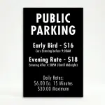 Custom multi-rate parking schedule A-frame sign with white text on black panel showing early bird rate, evening rate, and daily interval rate for Los Angeles parking lot