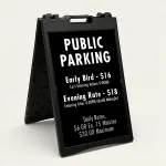 Custom multi-rate parking schedule A-frame sign with white text on black panel showing early bird rate, evening rate, and daily interval rate for Los Angeles parking lot