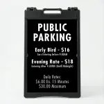 Custom multi-rate parking schedule A-frame sign with white text on black panel showing early bird rate, evening rate, and daily interval rate for Los Angeles parking lot