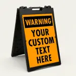 Custom orange and black warning A-frame sign with bold WARNING header and custom text zone for Los Angeles construction site parking lot or commercial facility