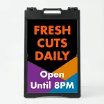 Custom black purple and orange geometric A-frame sign with bold orange message text on black panel and white additional text and phone number on colorful geometric lower section for Los Angeles creative business salon or cafe