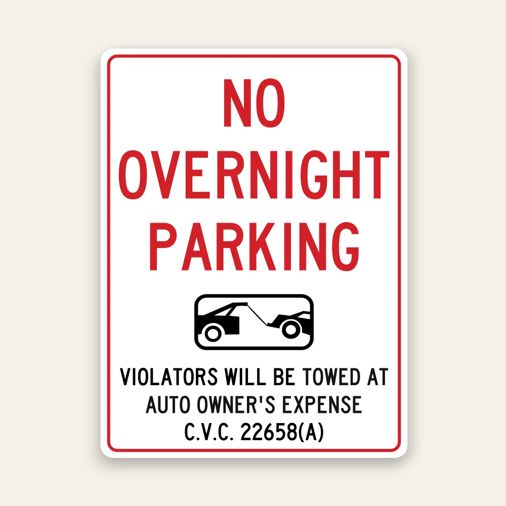 White No Overnight Parking sign with bold red text, black tow truck icon in center, and C.V.C. 22658A tow-away warning below.
