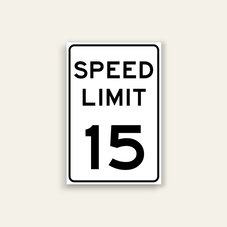 White portrait speed limit sign with rounded black border and black text reading SPEED LIMIT above a large numeral 15.