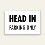 White landscape sign with bold black text reading HEAD IN above smaller PARKING ONLY text, no border.