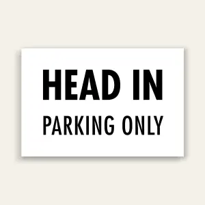 White landscape sign with bold black text reading HEAD IN above smaller PARKING ONLY text, no border.