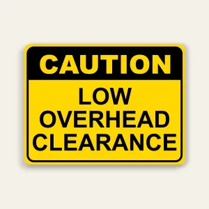 Yellow landscape caution sign with black header reading CAUTION above black text reading LOW OVERHEAD CLEARANCE in three lines, rounded black border.
