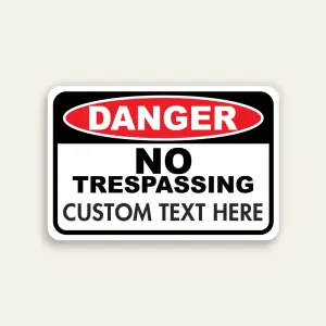 Red, black, and white Danger No Trespassing sign with ANSI DANGER oval, fixed NO TRESPASSING text, and Custom Text Here line below.