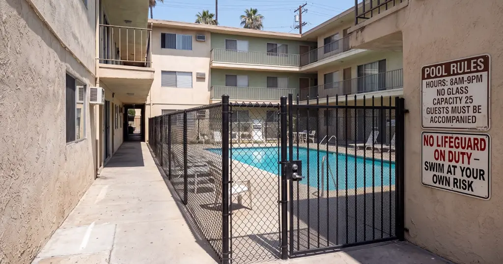 Pool safety signage and labeled recycling bins at a Los Angeles apartment complex